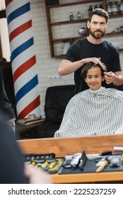 Cheerful Hairdresser Combing Hair Of Teen Customer In Barbershop