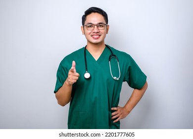 Cheerful Handsome, Asian Male Nurse Or Doctor In Green Scrubs, Stethoscope, Pointing Camera Showing You Opportunity Isolated White Background