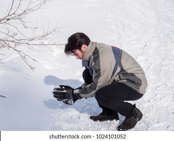 Cheerful Handsome Man In Outerwear Throwing Snowball Posing At Camera In Sunlight.