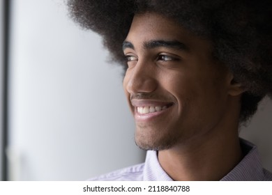 Cheerful Handsome Young Black Guy With Retro Afro Hairdo Looking Away, Dreaming With Toothy Smile, Enjoying Good Happy Thoughts, Thinking Over Future Vision. Dreamy African Man Close Up Portrait