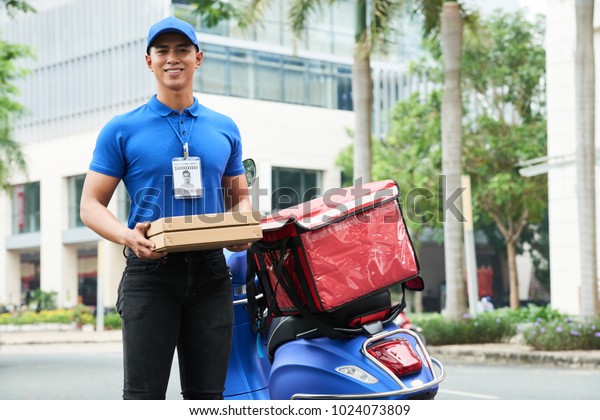 Cheerful Handsome Young Delivery Guy Holding Stock Photo (Edit Now ...