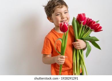 Cheerful happy child with tulips flower bouquet. Smiling little boy on white background. Mother's Day, March 8, International Women's Day concept