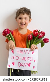 Cheerful happy child with tulips flower bouquet. Smiling little boy on white background. Mother's Day concept - Shutterstock ID 1928391911