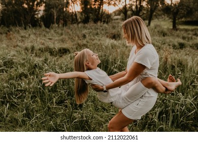 Cheerful Happy Family Mom Daughter Have Fun Playing Walking Summer Outdoors Together. Mother Hugging Girl Children Park. Parents Tickle Child. Blonde Child Sitting On Hands Laugh. Daughter And Mother