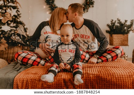 cheerful happy family in pajamas with a child kissing on the bed in the bedroom. new year family clothes looks outfits. Valentine's Day Celebration Gifts
