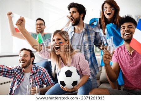 Cheerful and happy group of friends watching olympic games on tv.