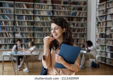 Cheerful Happy Latin Student Recording Voice Message In Library, Making Phone Call On Speaker, Talking, Giving Command To Electronic Voice Assistant On Smartphone, Laughing, Smiling