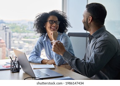 Cheerful happy multiethnic colleagues male indian and mixed race female sitting at desk with laptop working on project together discussing having fun. Corporate business collaboration concept. - Shutterstock ID 1986147434