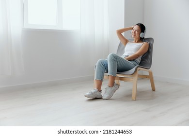 Cheerful happy relaxing tanned lovely young Asian woman in headphones dance move to music at home interior living room. Sound Studio Stream, Social media concept. Cool offer Banner Wide angle