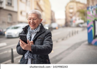 Cheerful Happy Senior Old Woman Talking On Her Cell Phone In The Street