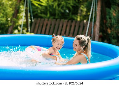 Cheerful healthy mother and daughter play in swimsuits in the pool. Time together, summer time, vacation - Powered by Shutterstock