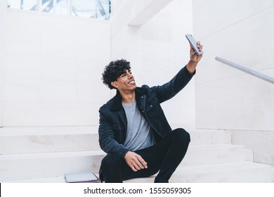 Cheerful Hipster Guy In Casual Wear Making Selfie On Front Camera Of Modern Smartphone Spending Time Outdoors, Happy Male Blogger Taking Picture For Share In Networks And Update Profile Via Cellular