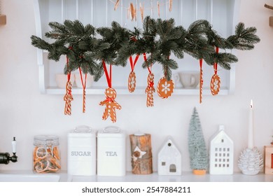 A cheerful holiday decor hangs above a kitchen counter, showcasing gingerbread ornaments and candy canes. Warm colors and festive elements create a cozy atmosphere for the season. - Powered by Shutterstock