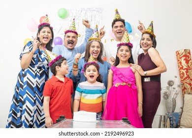 Cheerful Indian Asian Generational Family Celebrate Indoor Birthday Party.