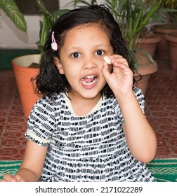 Cheerful Indian Asian Kid Or Toddler Girl Eating Roasted Lotus Pops Seeds Or Phool Makhana Or Fox Nuts From India. Healthy And Lunch Box Indian Snacks For Kids. Makhana From Bihar. Selective Focus. 