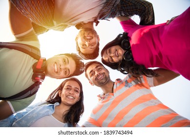 Cheerful Indian Asian Young Group Of College Students Forming A Circle, Looking Downwords At Camera