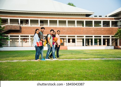 Cheerful Indian asian young group of college students or friends laughing together while sitting, standing or walking in campus