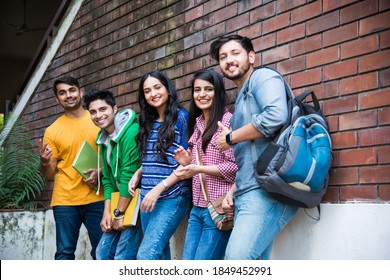 Cheerful Indian Asian Young Group Of College Students Or Friends Laughing Together While Sitting, Standing Or Walking In Campus