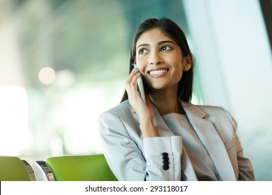 Cheerful Indian Business Woman Talking On Mobile Phone At Airport