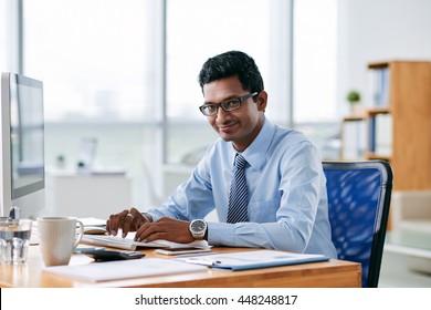 Cheerful Indian Businessman Working On Computer In His Office