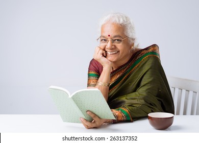 Cheerful Indian Woman In Glasses Reading A Book