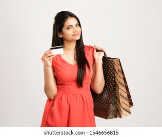 Cheerful Indian Young Woman With Shopping Bags And Credit Card On White.