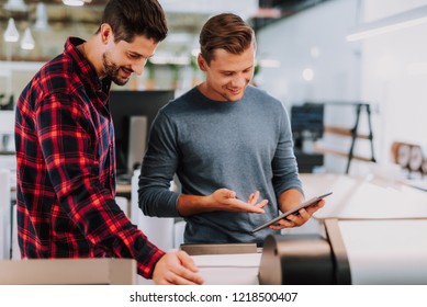 Cheerful ingenious startupers standing in the office while setting up their business - Shutterstock ID 1218500407