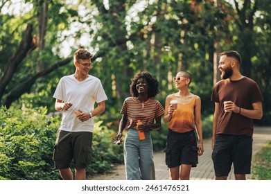 Cheerful interracial friends taking a walk in nature. Portrait of a young trendy hippie friends walking in nature, chatting and enjoying sunny summer day. Friends on a vacation enjoying sunny day. - Powered by Shutterstock