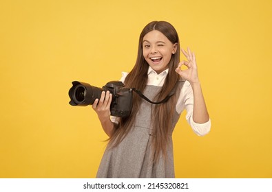cheerful kid girl take photo with digicam show ok gesture, photography