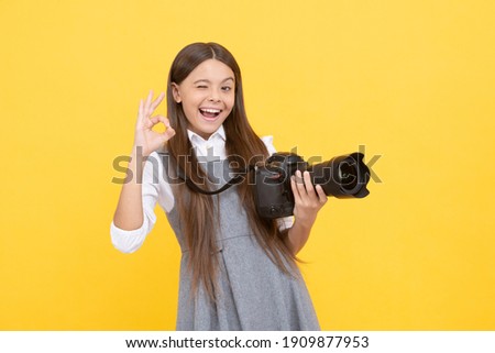 cheerful kid girl take photo with digicam show ok gesture, photography.