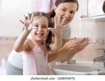 fröhliches Kind, das Hände waschen und Seifenpalmen zeigen