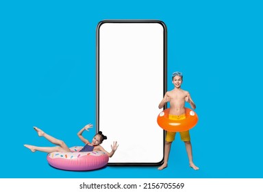 Cheerful Kids With Inflatable Pool Circles Having Fun Near Big Blank Smartphone, Happy Excited Teen Boy And Girl Advertising New Mobile App Or Website With Summer Vacation Offer, Mockup
