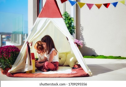 Cheerful Kids Are Playing In Teepee Tent On A Sunny Patio