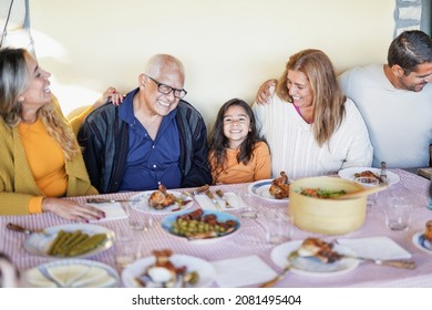 Cheerful Latin Family Eating Lunch Together At Home On Patio