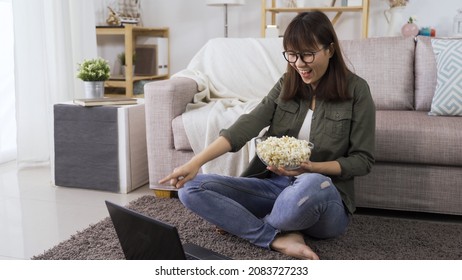 Cheerful Laughing Female Student Eating Popcorn And Watching Funny Episodes Online Movie On Laptop Pc While Holding Owl Of Popcorn