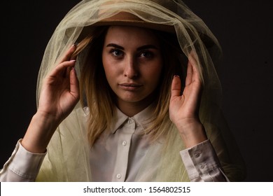 Cheerful Laughing Girl With Brown Hat Wrapped In Tulle On A Dark Background