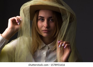 Cheerful Laughing Girl With Brown Hat Wrapped In Tulle On A Dark Background