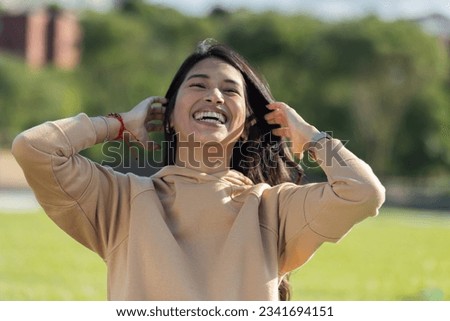 cheerful laughing girl on the street in yellow sweatshirt