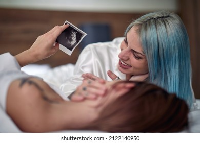 Cheerful Lesbian Couple Sharing Hapiness Of A Pregnancy Together