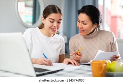 Cheerful LGBT Couple Working With Papers, Planning Wedding Or Family Budget While Sitting At Table With Laptop At Home