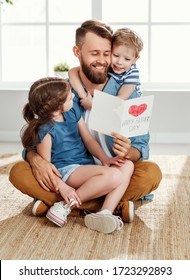 Cheerful little boy and girl congratulating happy dad with Fathers day and giving handmade greeting card while spending holiday together at home