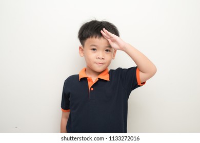 Cheerful Little Boy Putting A Hand On The Forehead Greeting, Isolated On A White Background.