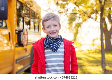 Cheerful Little Boy Standing Near Schoolbus Ready To Go To School, Back To School Concept