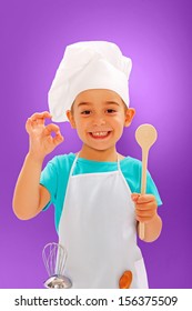 Cheerful Little Chef Showing Good Taste And Wooden Spoon