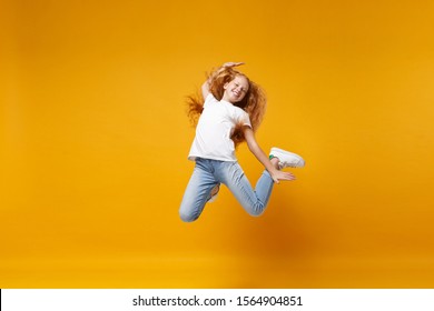 Cheerful little ginger kid girl 12-13 years old in white t-shirt isolated on yellow background children portrait. Childhood lifestyle concept. Mock up copy space. Having fun, fooling around, jumping - Shutterstock ID 1564904851