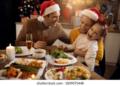 Cheerful little girl having fun with her parents during Christmas lunch at home.  - Powered by Shutterstock