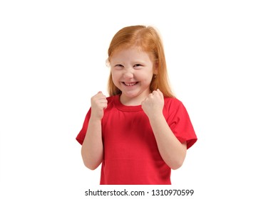 Cheerful little girl, look so excited she is raising her fists up, isolated on white background.