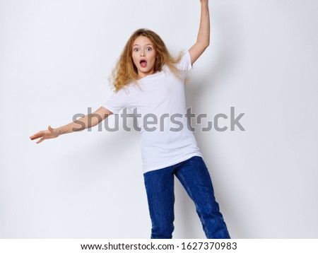 Cheerful little girl in a white T-shirt jeans studio lifestyle white background