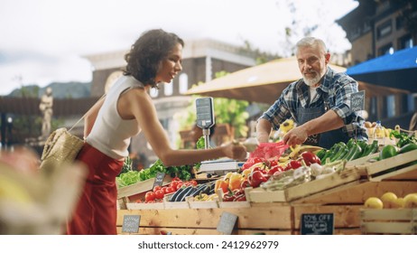 Cheerful Local Farmer Running a Small Business, Selling Sustainable Farm Fruits and Vegetables. Happy Middle Aged Male Welcoming a Female Shopper to Try Tomatoes and Other Organic Produce From a Farm - Powered by Shutterstock