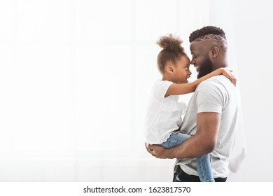 Cheerful loving african american father carrying his little preschool daughter, white background, copy space - Shutterstock ID 1623817570